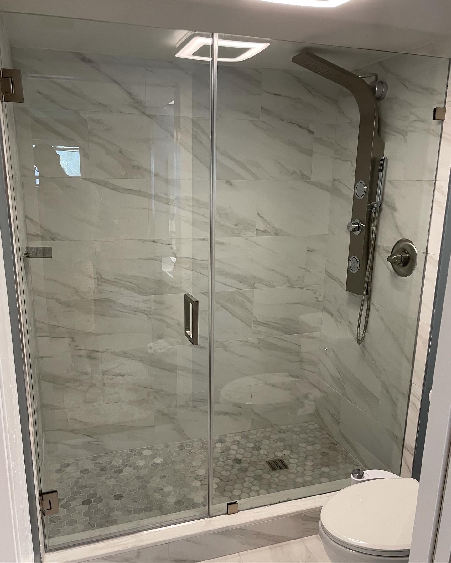 Porcelain Marble Modern Bathroom Remodel with Silver Accents by Anchor Construction